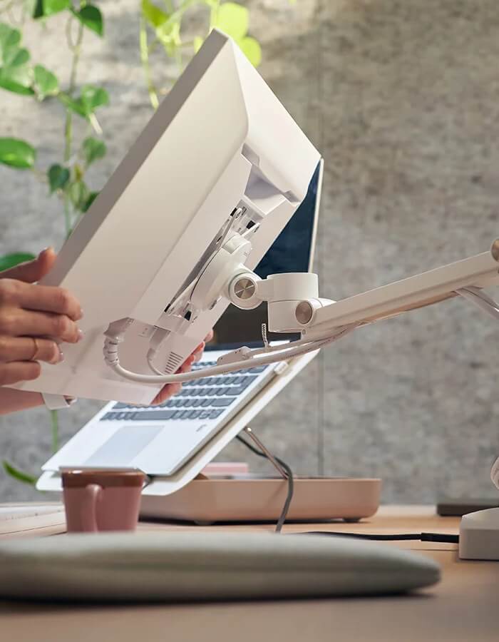 Bijeli nosač za monitor VIEWLITE pričvršćen na radni stol